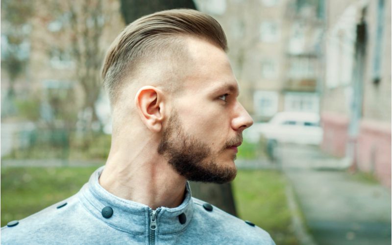 Zijprofiel foto van een man met een Pompadour Bald Drop Fade