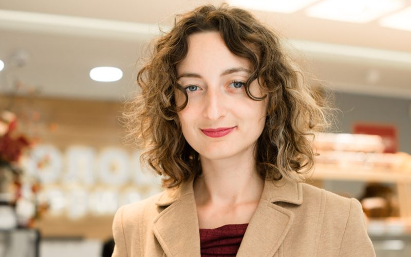 Curly Curtain Bangs op een bleke vrouw in een winkel met een bob