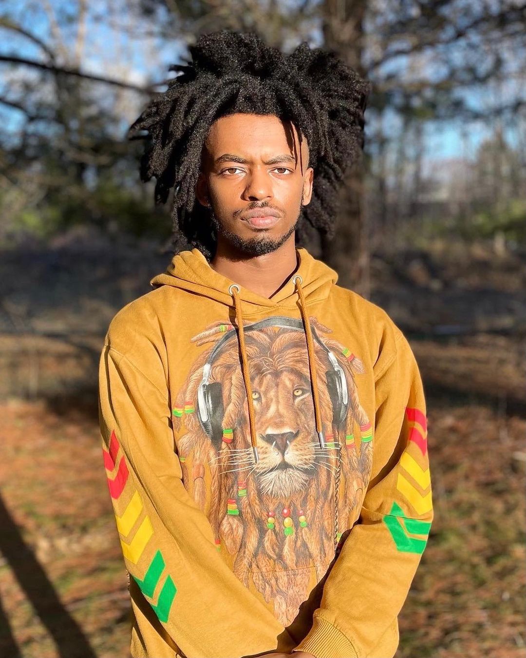 Man in een oranje leeuwen capuchon met freeform dreads