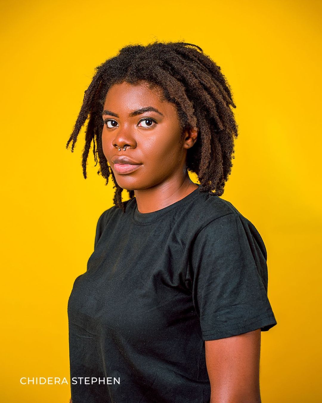 Vrouw met freeform loc 4c haar staat in een oranje kamer