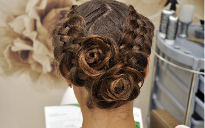 Dubbel gevlochten moeder van de bruidegom kapsel, een elegante look op een vrouw in een salon