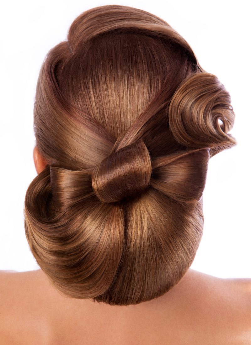 Voor het kapsel van de moeder van de bruidegom bond een vrouw haar haar in een strik en poseerde in een studio voor deze foto.