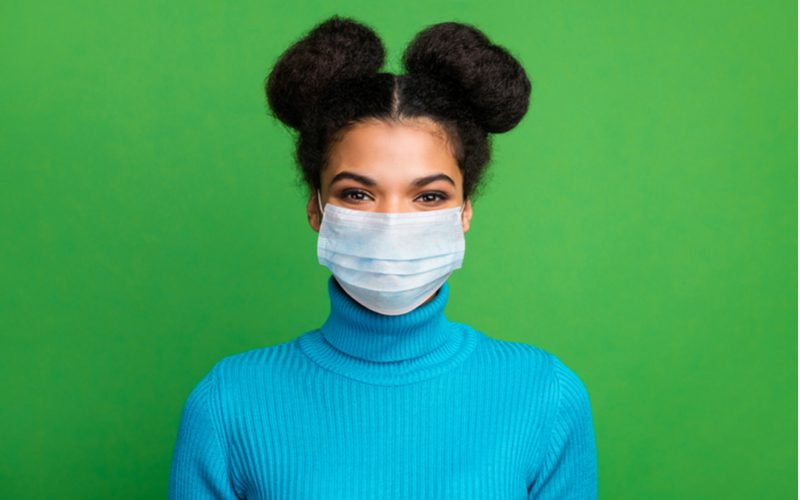 Double space buns op een zwarte vrouw in een blauwe coltrui