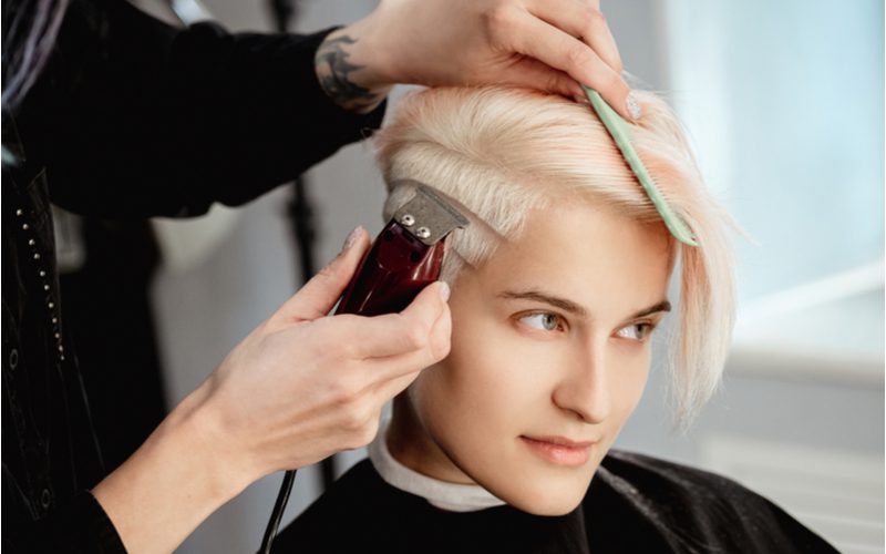 Gal met een lange pixie met veren krijgt een undercut in de onderkant