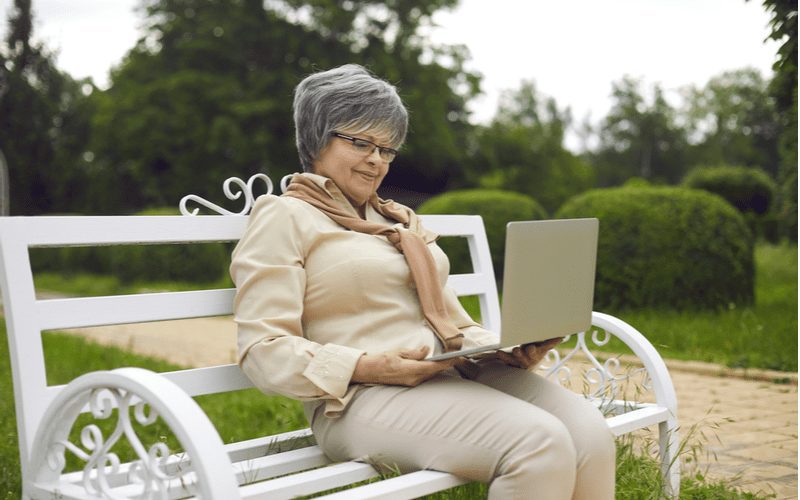 Voorbeeld van een kort kapsel voor oudere vrouwen op een dame in een buttonup shirt kijkend naar een laptop