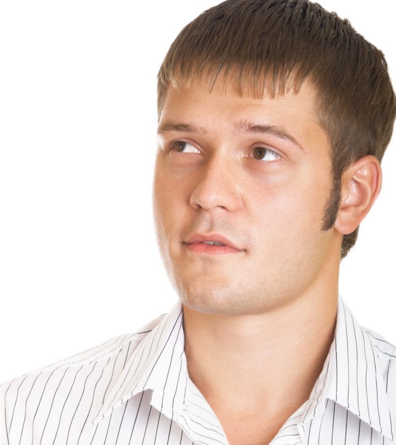 Man in een gestreept overhemd met brede kraag kijkt naar rechts en grijnst