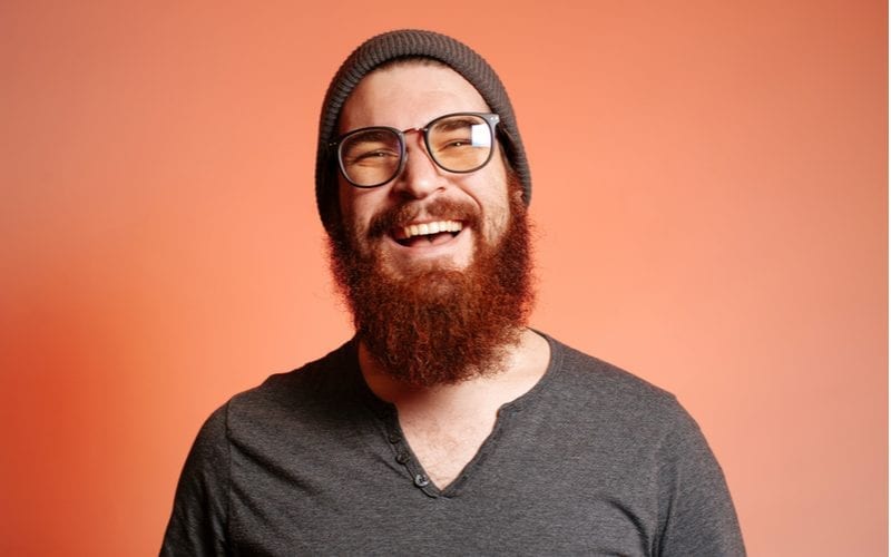 Close up portret van gelukkige glimlachende bebaarde hipster man met bril en vol vertrouwen kijkend naar de camera