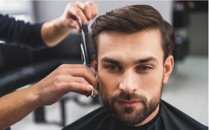 Bekwame kapper die mannelijk haar knipt