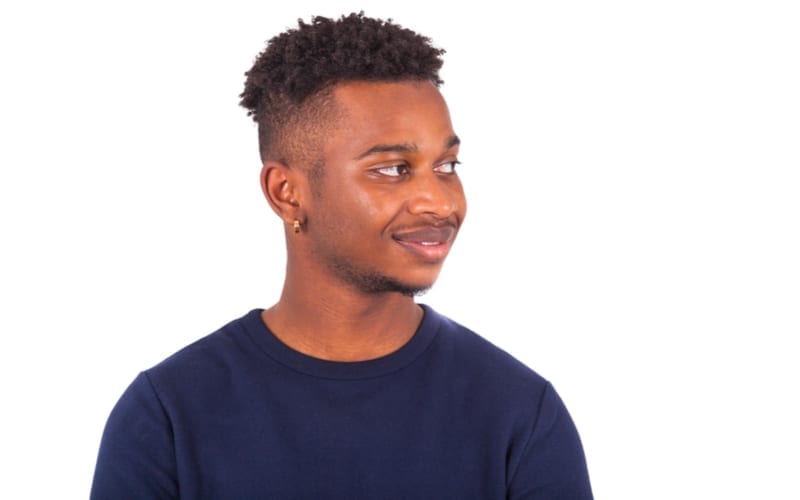 Gelukkige jonge afrikaanse amerikaanse mens die op witte achtergrond wordt geïsoleerd