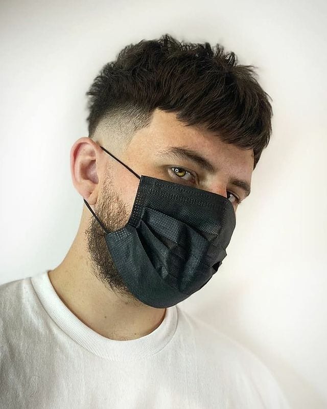 Pluizig textuur mannenkapsel op een kerel in een masker met een baard