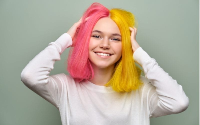 Vrouw met een half e-girl kapsel met half geel en half roze