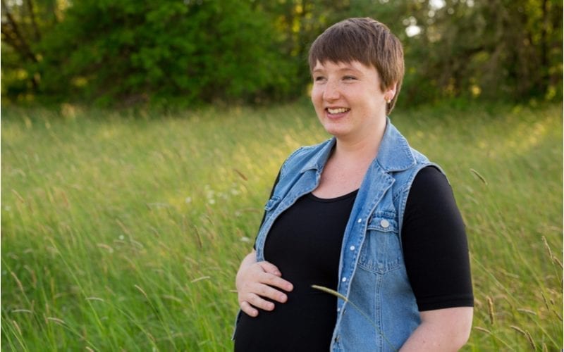 Zwangere vrouw in een veld voor zwangerschapsfoto's