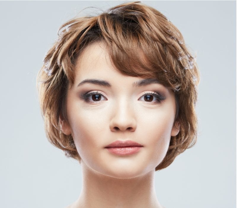 Jonge vrouw met een kort shag kapsel close up gezicht schoonheid portret.Kort Haar stijl. Vrouwelijk model geïsoleerde witte achtergrond.