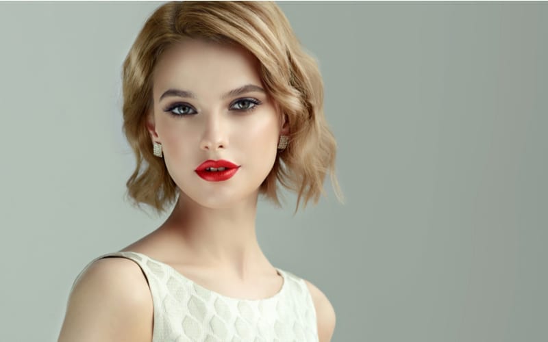 Mooi model meisje met kort krullend haar en rode lippen