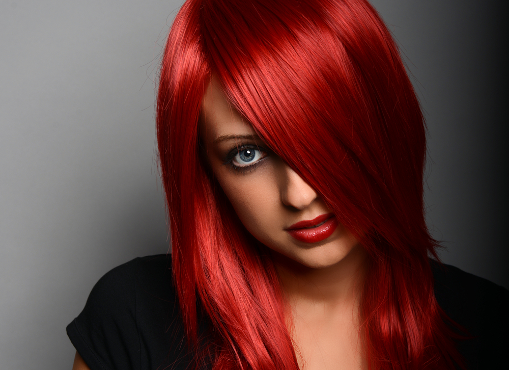 Bright Scarlet onnatuurlijke haarkleur voor blauwe ogen op een vrouw die sensueel naar de camera kijkt met rode lip