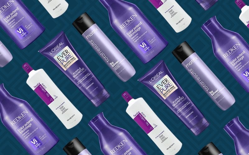 Paarse shampoo producten uitgespreid tegen een blauwe achtergrond