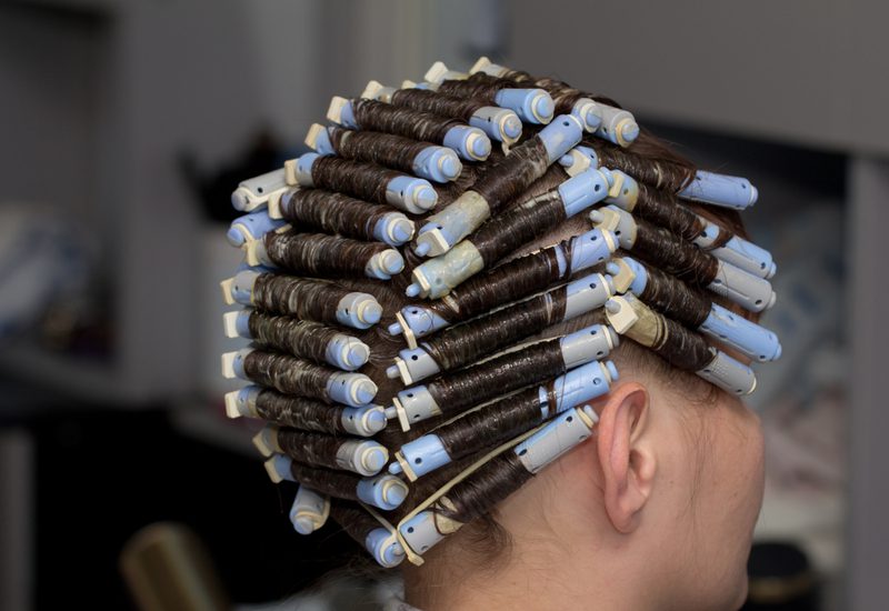 Vrouw die leert hoe ze gepermanent haar moet hydrateren krijgt een permanent in een salon