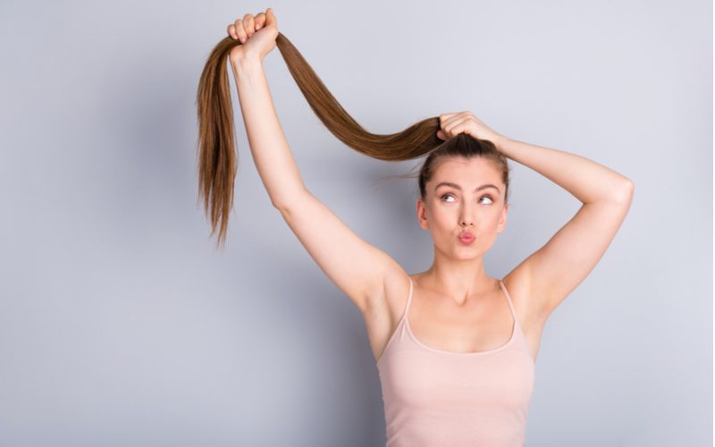 Stuk over hoe een verlengde paardenstaart te doen met een vrouw die haar haar vasthoudt