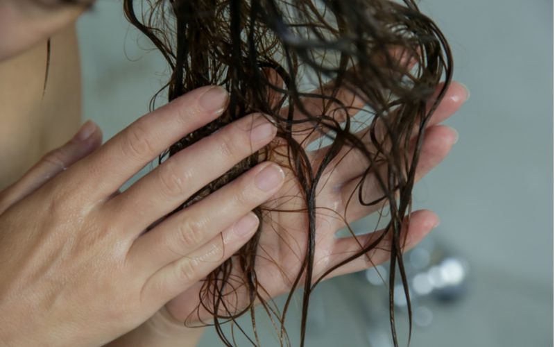 Voor een stuk over hoe krullend haar te drogen, en beeld van nat haar dat in een badkuip wordt uitgespoeld
