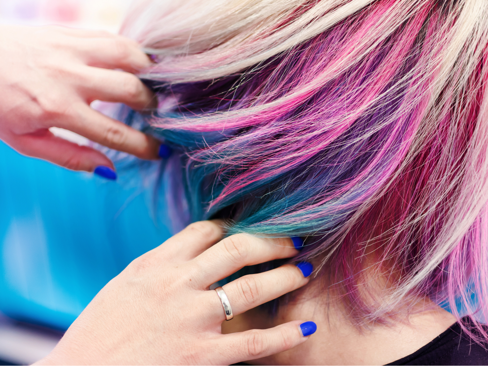 Voor een stuk getiteld How Long Does Purple Hair Dye Last, een vrouw die de achterkant van haar paarse haar in een bob cut uitwaaiert