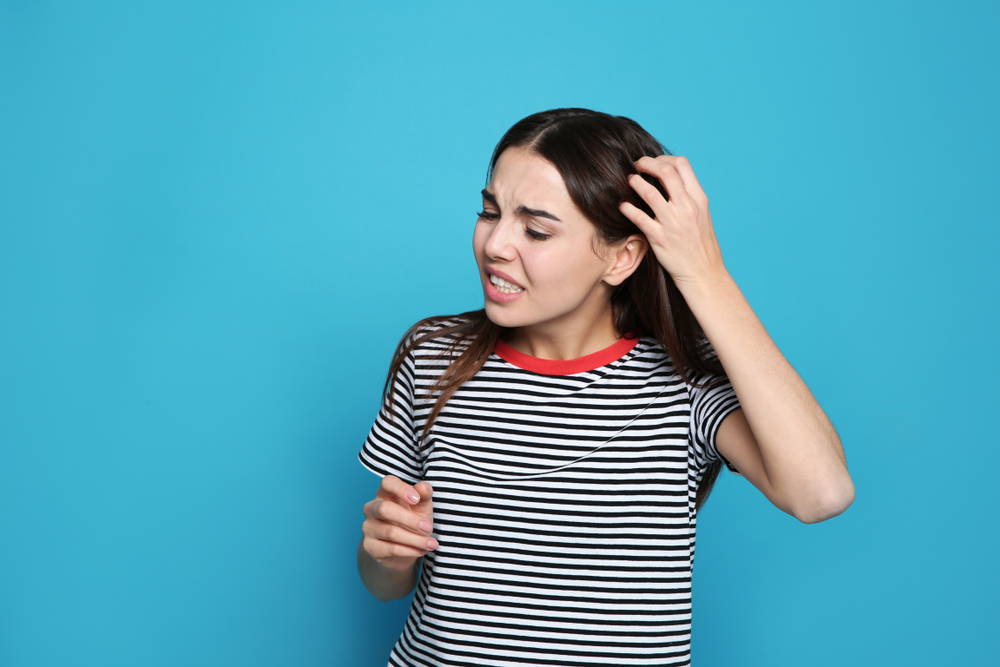 Vrouw die Olaplex 's nachts liet zitten krabt aan haar hoofd om hoofdhuidpijn te verlichten