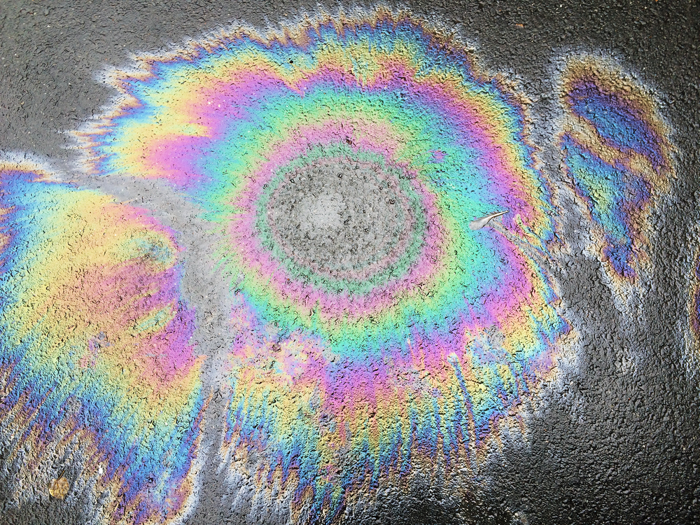 Olie gemorst op beton voor een stuk over hoe oil slick hair eruit ziet