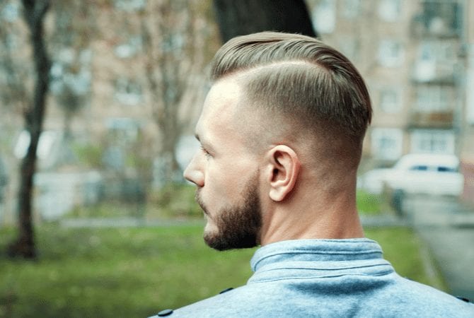 Man met een sportief fade kapsel kijkt van achteren naar links voor een stukje over soorten fades