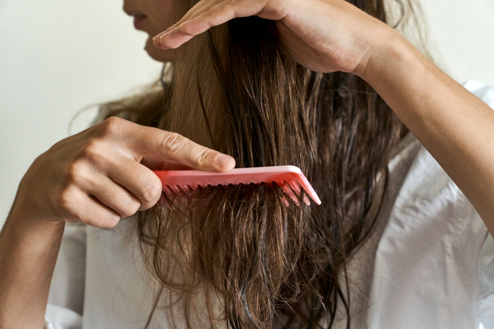 Vrouw ontklit haar haar om het te wassen na een keratine behandeling