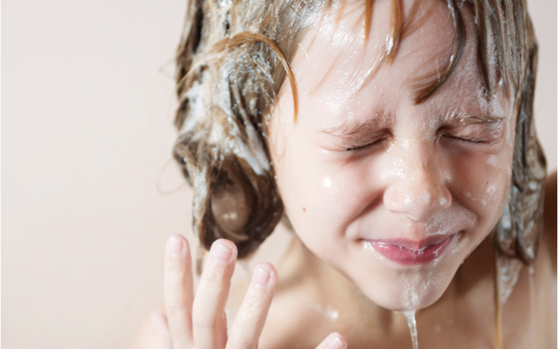 Meisje dat een traanvrije shampoo gebruikt voor een stuk waarin ze uitlegt wat het is