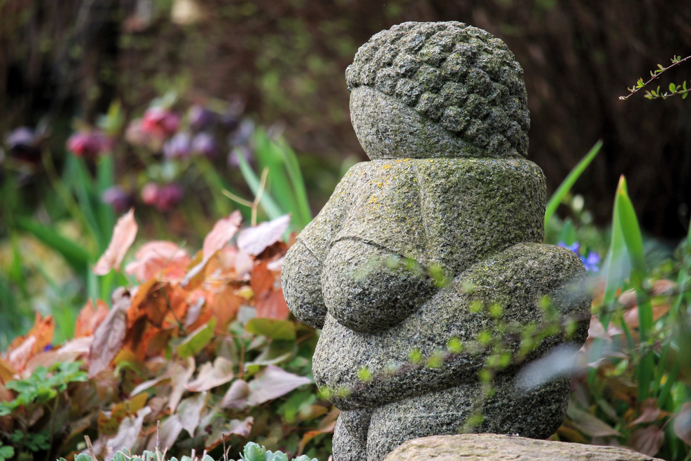 Beeld van de Venus van Willendorf, een beeld in de tuin, voor een stuk over wie vlechten heeft gemaakt