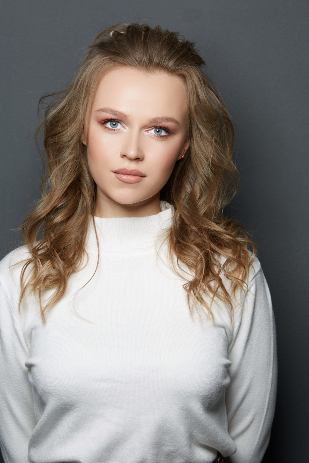 Donker Taupe Blond haar op een vrouw in een wit shirt voor een donker blond haar roundup