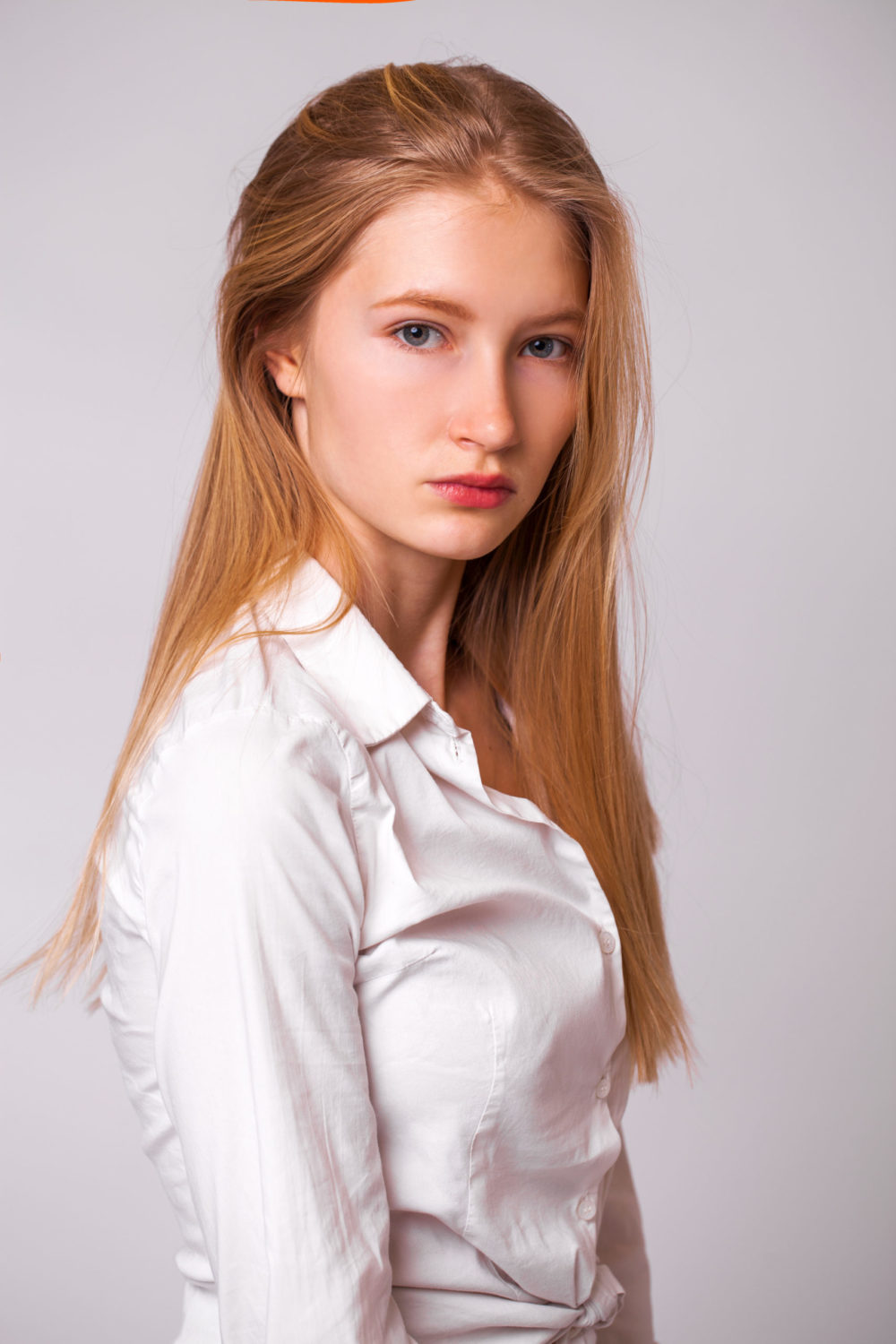 Donker Koper Blond haar op een vrouw in een wit button-up shirt