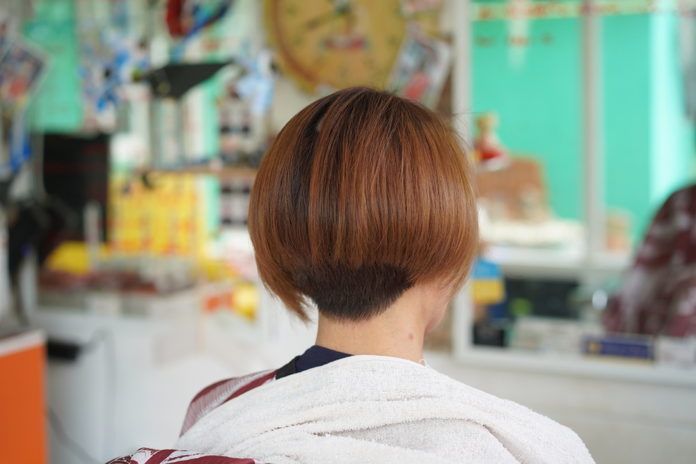 Voor een kenmerkend taps toelopend kapsel voor vrouwen, draagt een vrouw een Inverted Tapered Bob