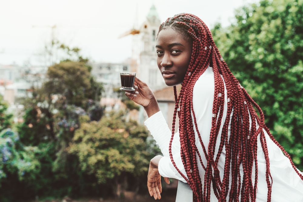 Als onderdeel van een roundup van vlechten met kralen, draagt een vrouw Red Feed-In Box Braids With Silver Cuff Beads