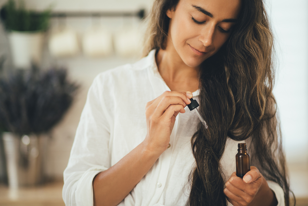 Vrouw brengt pompoenzaadolie aan op haar haar