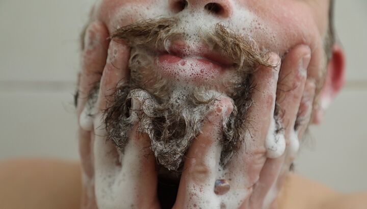 Man wast zijn baard met shampoo