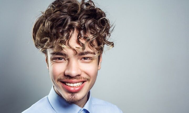 Glimlachende Jonge Man Met Lange Krullen