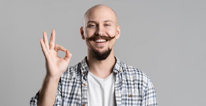 Kale man met snor die oké teken toont