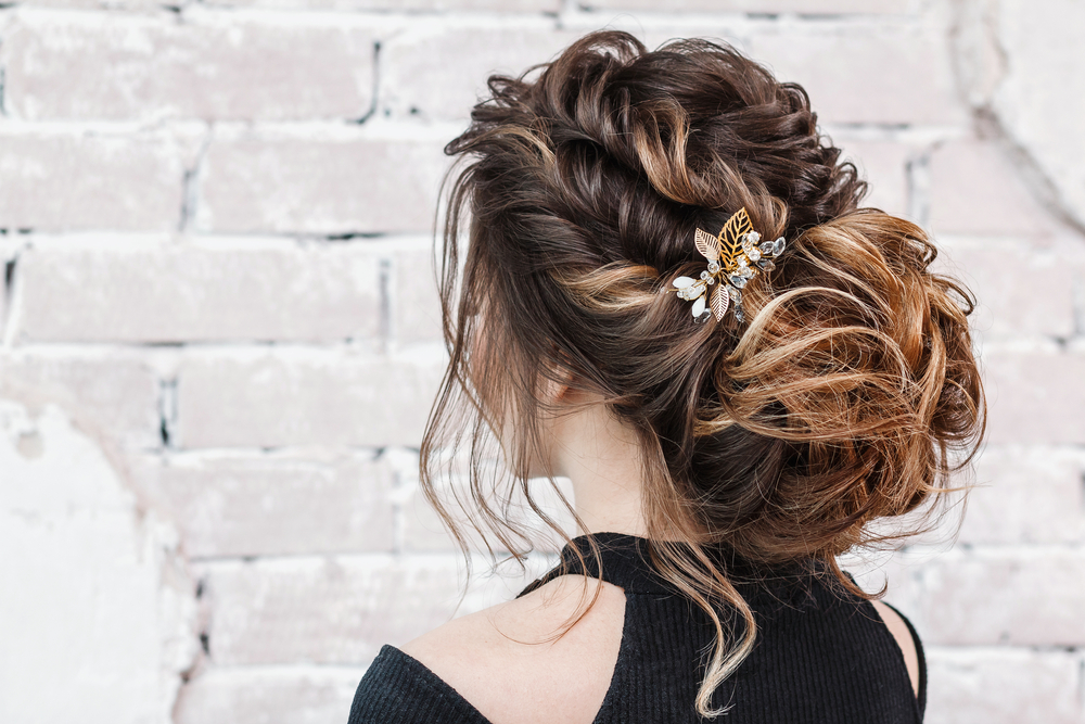 Low Tousled Bun With Loose Twists, een van de beste prom kapsels om dit jaar te dragen.