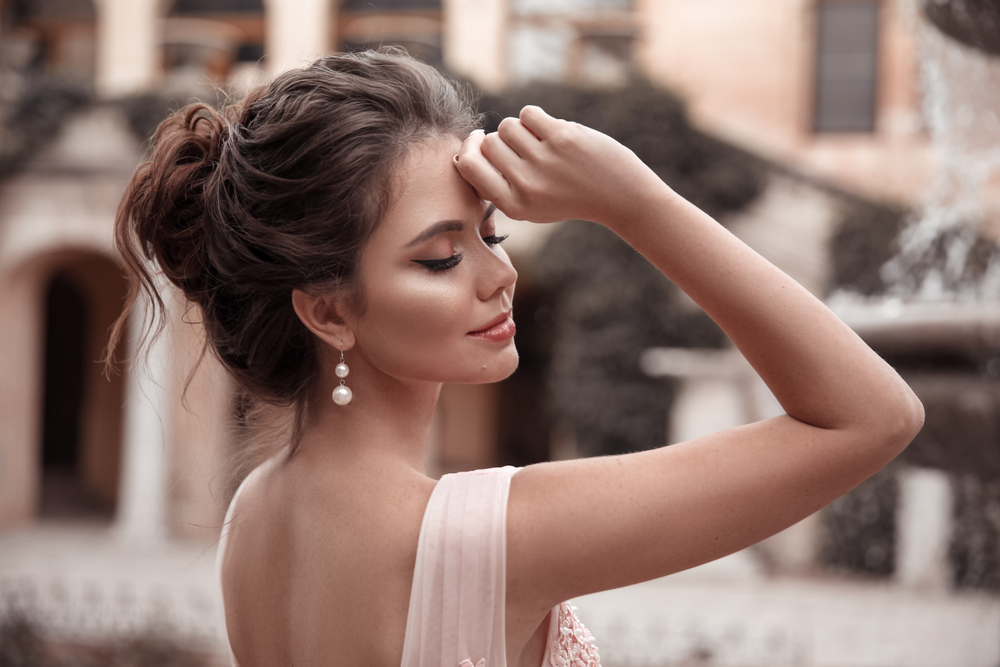 Als promokapsel draagt een vrouw in een crème hemd een Loose Messy Updo.