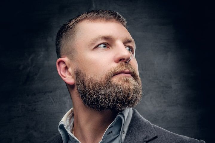 Portret van een man met een dikke baard van drie maanden