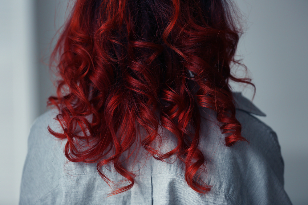 Sanguine Rood haar op een vrouw in een spijkerjasje voor een stuk over de beste kleuren voor rood haar