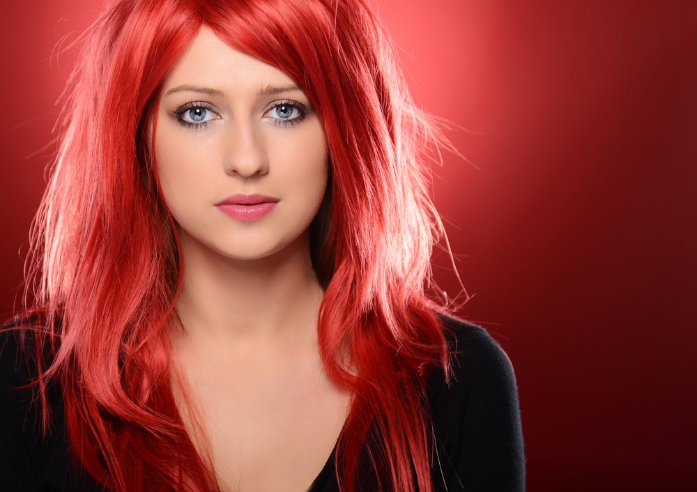 Voor een roundup van de beste haarkleuren voor rood haar, draagt een vrouw Watermeloenrood haar en een zwart shirt
