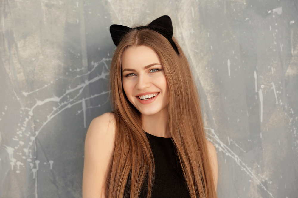 Vrouw glimlachend met donker aardbeiblond haar en kattenoren