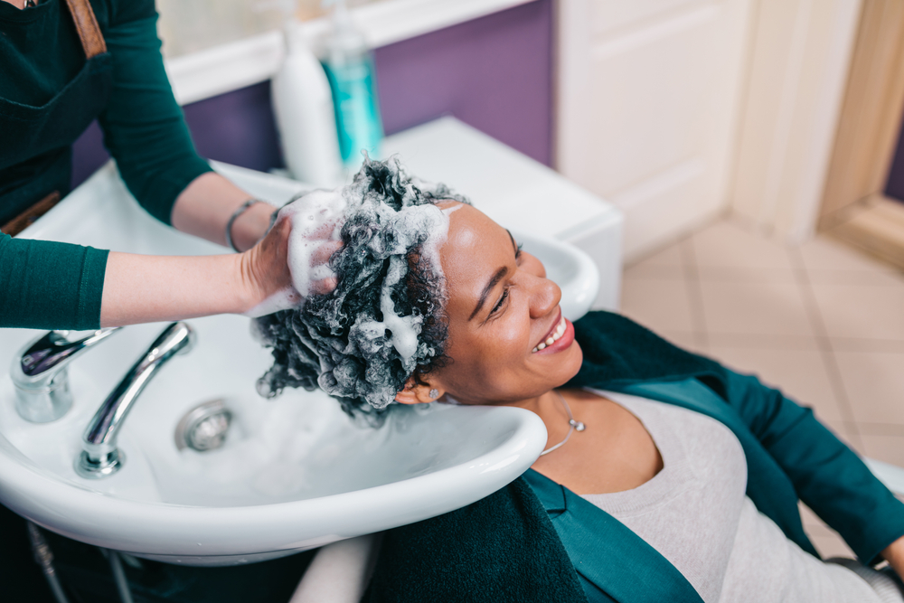 Vrouw die de beste shampoo en conditioner voor zwarte haargroei gebruikt