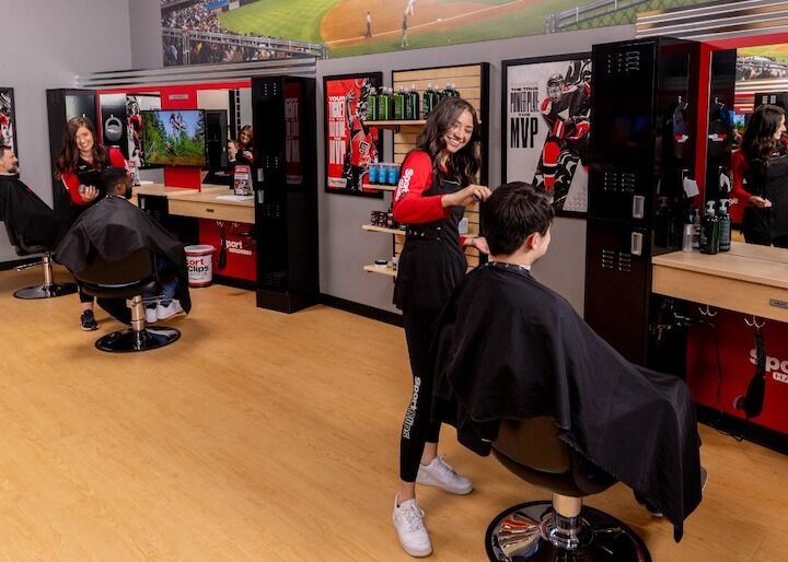 Het glimlachen Dame Hairstylists die met Klanten van Sport Cuts Kapsels werken