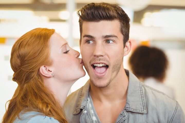 Redhead Girl Kissing a Young Man in the Cheek