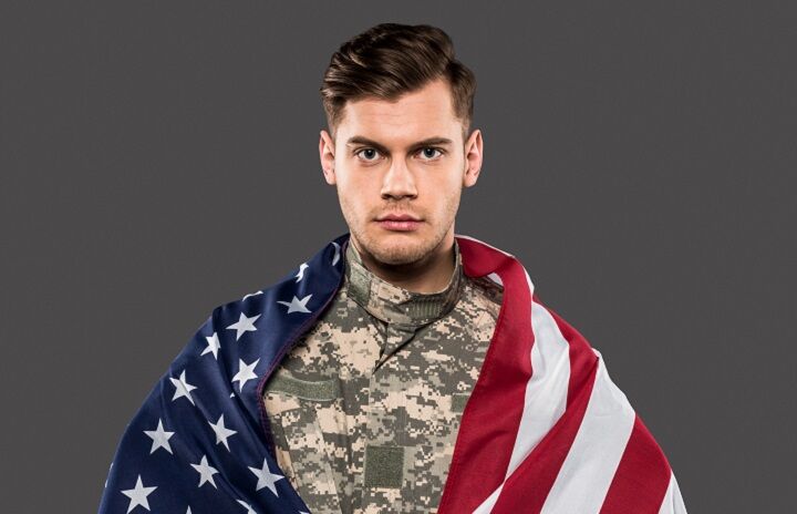 Man met militair kapsel in een uniform met Amerikaanse vlag