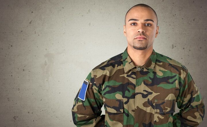 Man met kort militair kapsel en sik baard in een uniform