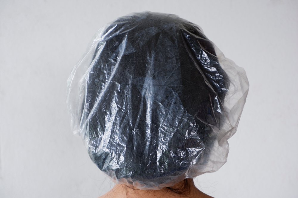 Vrouw draagt een douchemuts na gebruik van haarverfverwijderaar om van zwarte haarverf af te komen
